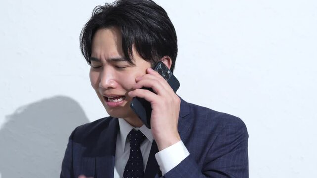 携帯で謝るビジネスマン