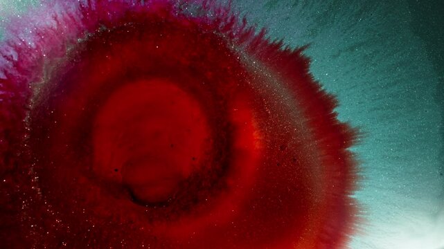 Swirling red ink and vibrant blue liquid mixing in a captivating macro shot