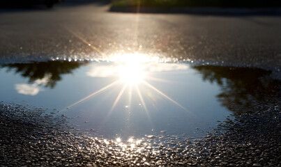 the sun reflected in puddle. generative ai