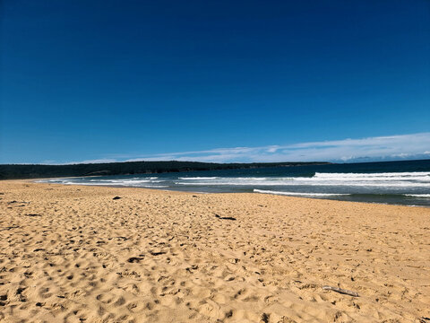 Beautiful sandy Aslings Beach with waves crashing onto the shore. Taken at Eden on the New South Wales far south coast Australia