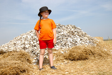 girl standing by oyster shell mountain (conceptual)