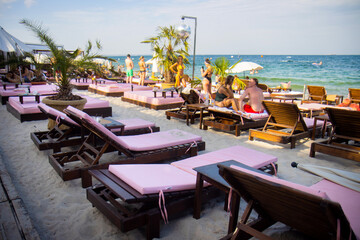 vacationers relaxing on beach sun loungers