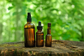 set of amber glass bottles of herbal essence extract in forest close up, natural background. eco friendly care organic product. beauty treatment, Spa, Cosmetic product concept