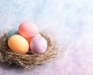 Obraz premium Delicate pastel Easter eggs are set in a woven nest with soft watercolor textures, and pink, blue and yellow tones blend into a dreamy spring background.
