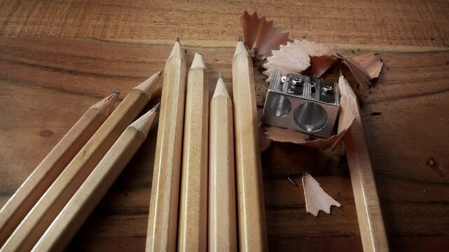 Pencil sharpener shavings and plain pencils close up stock footage