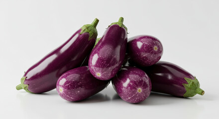 Pile Of Fresh Eggplants Displayed Against A Plain White Backdrop With Rich Purple Hues And Green Stems