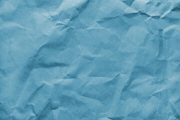 Recycled crumpled blue colored paper texture. Wrinkled craft paper background, rough cardboard...