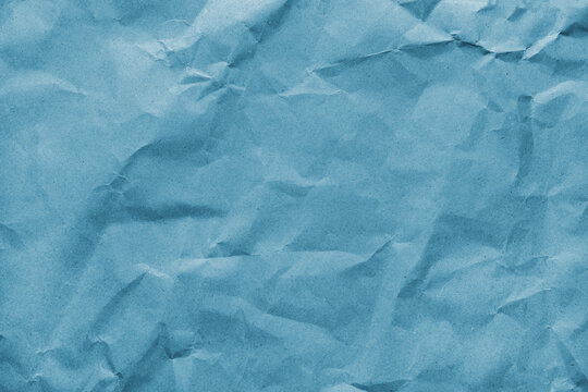 Recycled crumpled blue colored paper texture. Wrinkled craft paper background, rough cardboard surface, wallpaper, backdrop. Design element, copy space for text