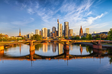 Sunrise view of the modern skyline of Frankfurt, Germany, with golden sunlight shining on the office skyscrapers of the city