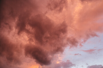 Fiery red storm clouds with dramatic lighting. Red storm clouds background. Dramatic red sky.