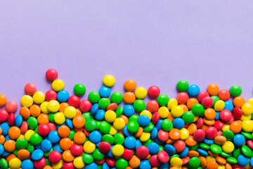 Mixed collection of colorful candy, on colored background. Flat lay, top view. frame of colorful chocolate coated candy
