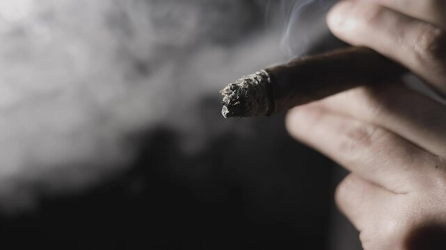 Cuban cigar, Man smoked and holding a cigar in his hand close-up,