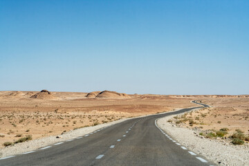 Desert road under blue sky in southern Algeria