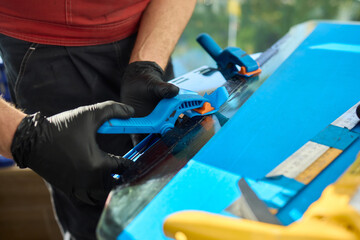 A skilled craftsman is diligently using various tools to achieve precision work on a blue project