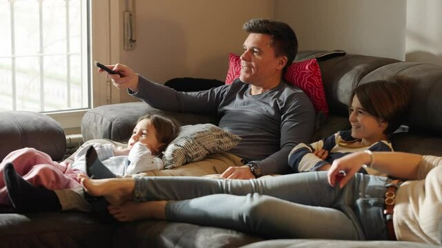 Family watching television together on sofa