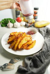 Preparation Squeeze the sauce on the crispy baked potatoes with delicious paprika powder. Cook in the kitchen at home, homemade style. vertical photo