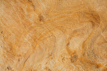 Natural texture background of sandstone rocks with lines, curves, prints in the As Amoeiras and Formosa beach cliffs in Santa Cruz, Portugal.