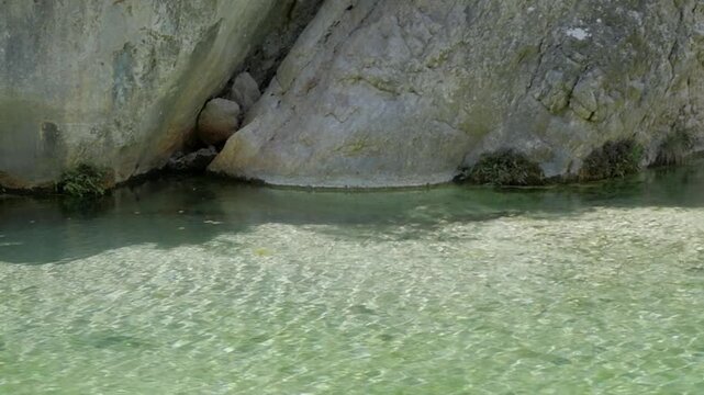 Clear shallow stream at Parrizal de Beceite, rocky cliffside, calm peaceful vibe