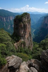 Majestic rock formation in lush green canyon landscape under blue sky