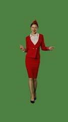 Young Woman in Red Uniform Expressing Joy on Green Background