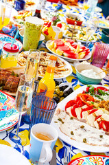 vertical photo of brunch table full of delicious food and drinks, avocado, plates, limonade,