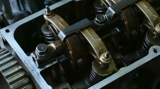 Precision-engineered rocker arms and valves revealing intricate mechanical details within car engine cylinder head, showcasing complex internal combustion system components
