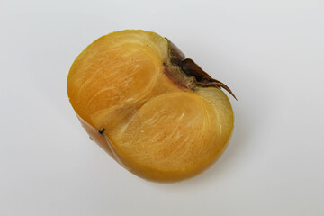 A cut flesh persimmon fruit, isolated on white background