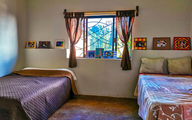 Simple small apartment hotel room with bed table in Mexico.
