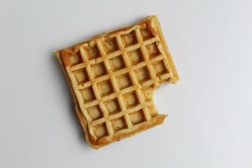 One bitten plain waffle cake, isolated on white background, flat lay or top view