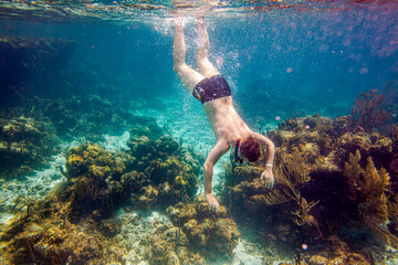 Snorkeling and skin diving on the coral reef edge in tropical waters...