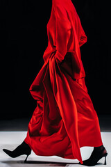 Bright red women's outfit long silk skirt and knitted cardigan on black background