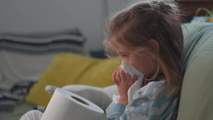 Cute young girl sitting on couch at home, blowing her nose with tissue, looking unwell and tired, suffering from cold or flu, surrounded by toilet paper, in cozy indoor setting - Powered by Adobe