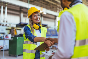 Professional Workers Collaborating in Factory Setting with a Handshake Gesture