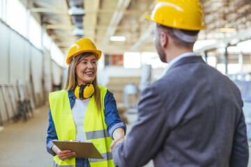 Construction Team Member Shaking Hands in Industrial Warehouse Environment