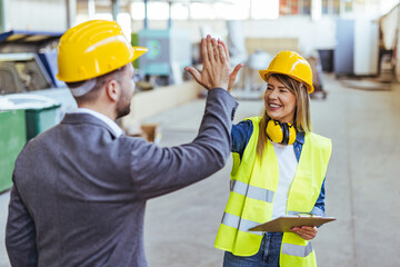 Team Members Giving a High-Five at Construction Site for Job Well Done