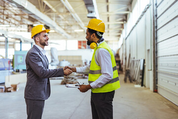 Business Meeting Between Engineer and Manager in Industrial Warehouse