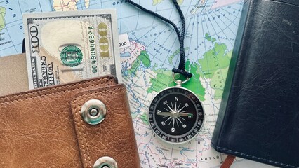leather wallet with cash, compass, and world map for travel adventure concept