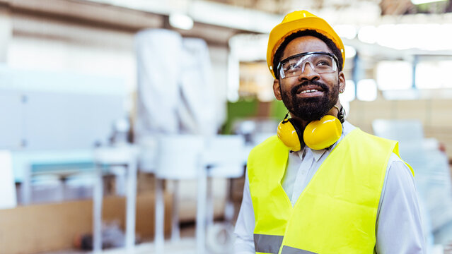 Portrait of a Confident Factory Worker Wearing Safety Gear in Workplace