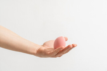 hand holding makeup sponge on white background