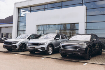 New suv cars parked in front of modern car dealership building