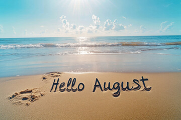 Hello august written on beach sand at sunset welcoming summer month