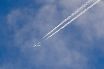 Airplane flying at high altitude leaving contrails in the sky