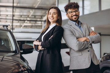 Car salespeople standing back to back in a dealership