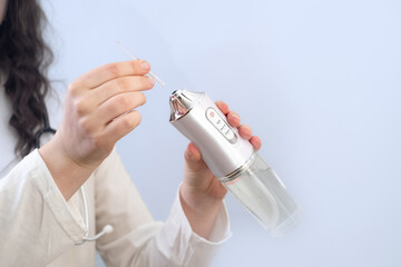 Female dentist shares tips on daily teeth care using an irrigator for better oral hygiene.