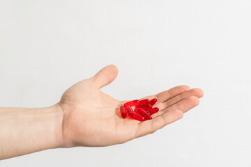Tablets and pills on the palm of a person. Man holds a lot of pills in hands. Top View