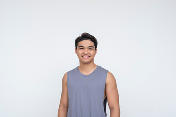 A young Southeast Asian man smiles confidently at the camera, standing in relaxed sleepwear and looking refreshed. Isolated on a light background.