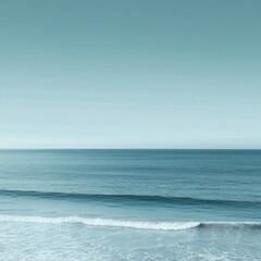 Obraz premium Tranquil ocean vista. Gentle waves cresting a serene shoreline. Pale, diffused light bathes the scene in a calming atmosphere
