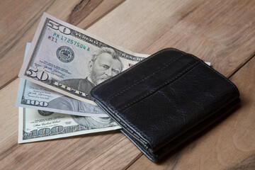 Pile of US dollar banknotes in black leather wallet