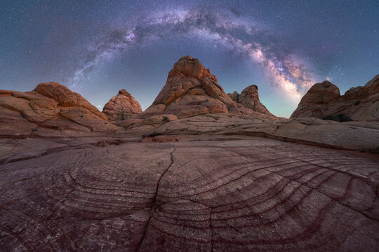 Milky Way Arches Over Rocky Desert Terrain at Night in Coyote Buttes