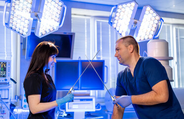 Surgeons prepare for surgery. Two healthcare workers in scrubs discuss surgery in a bright, modern...